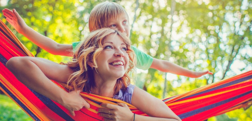 Happy woman in hammock with son